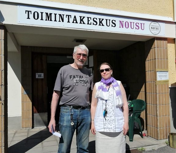 Yhdistyksen sisäänkäynti ja kaksi henkilöä