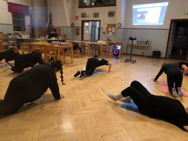 Ihmisiä jumppaamassa lattiatasossa.