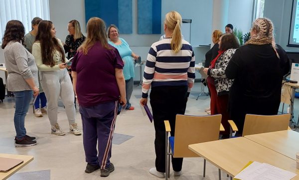 ryhmäliikunta alkamassa, ihmisiä liikuntavaatteissa sisällä